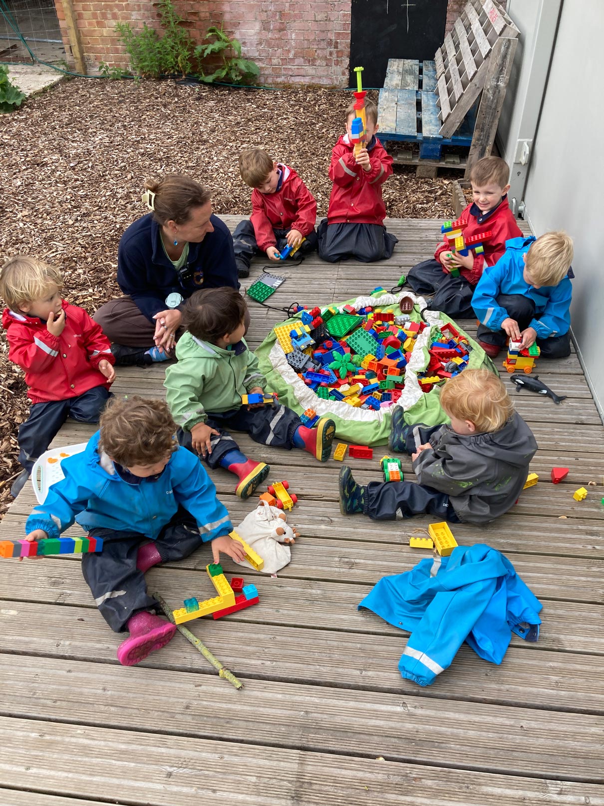 EYFS outdoor construction play session promoting toddler fine motor skills, spatial awareness, and creative building with blocks.